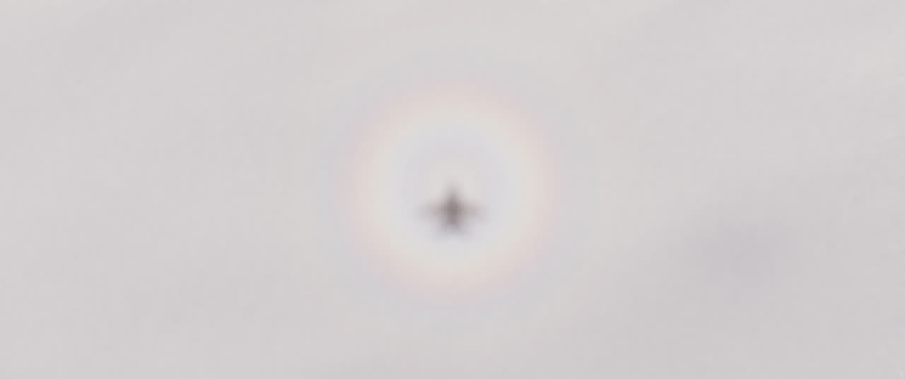 The shadow of a whole F-16, wings, tail and stabilators, on the cloud 150 metres below, inside the glory