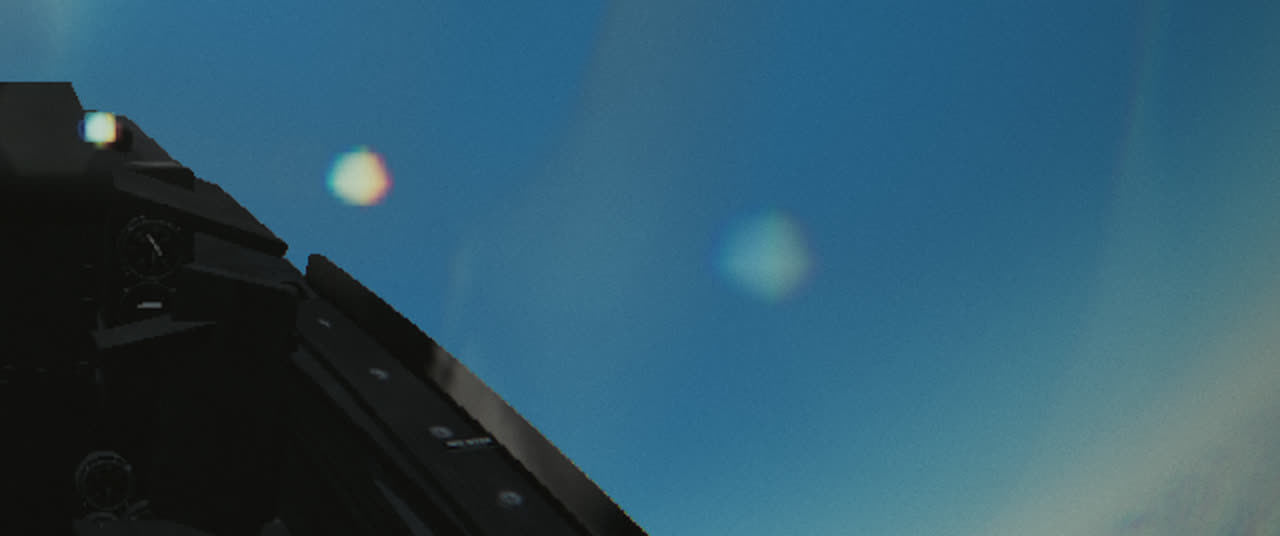 Two hard-edged lens ghosts beside the canopy frame at 14,000 feet
